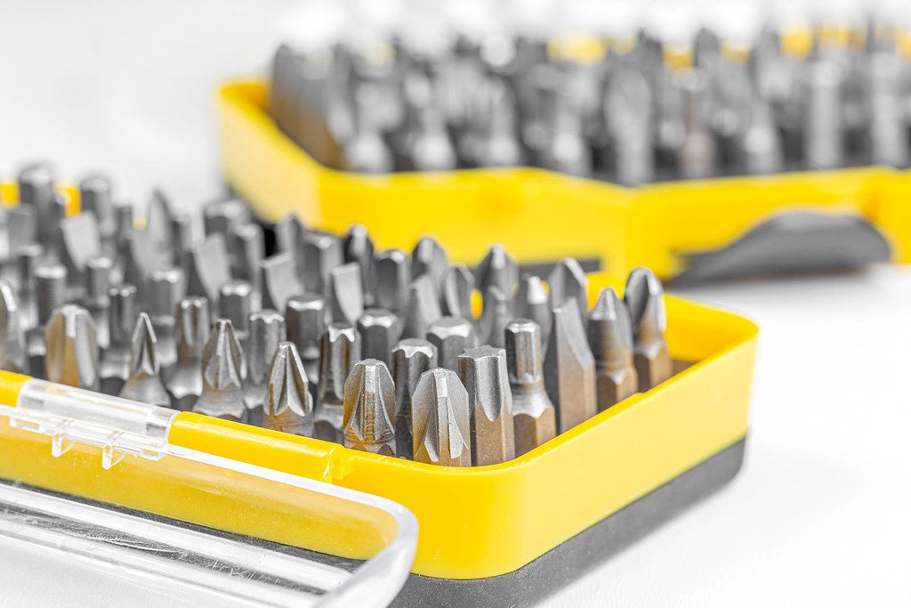 Set of screw tips in a yellow container on a white background
