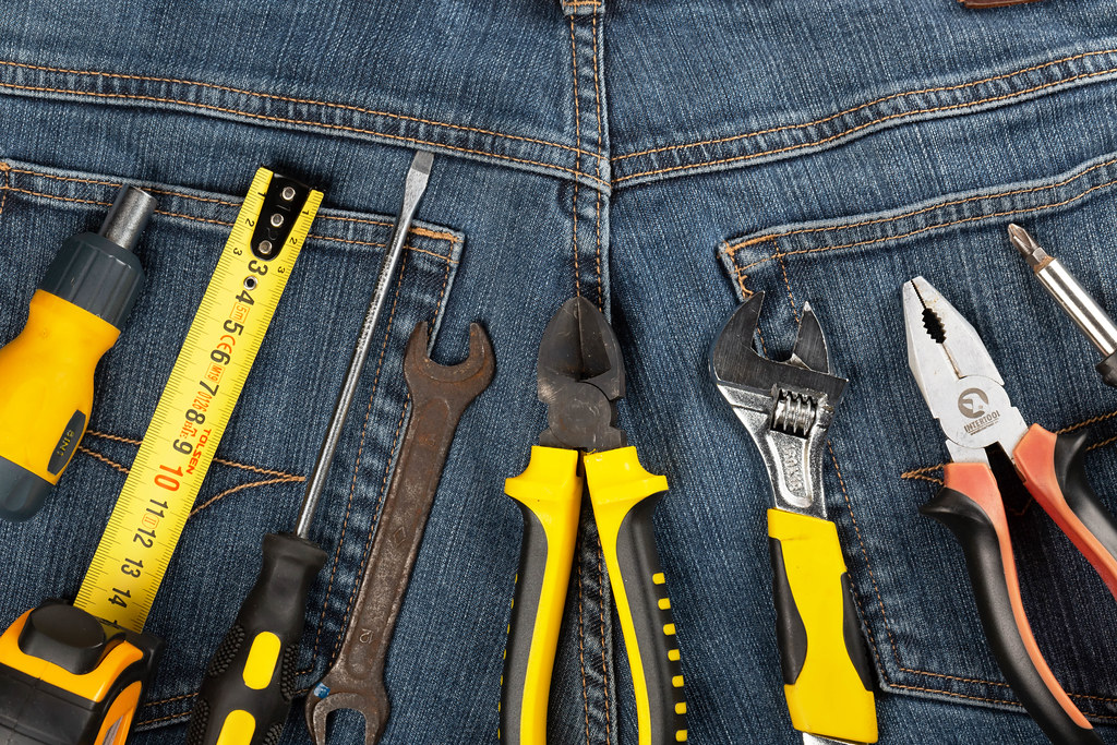 Set of working tools on jeans background, top view