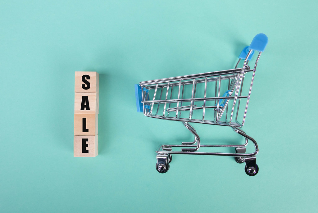 Shopping cart with Sale text on wooden blocks