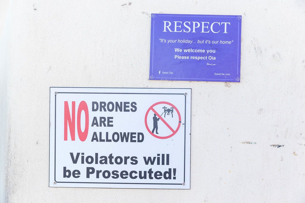 Signs from residents ask tourists to respect privacy and not use drones in Oia, Santorini