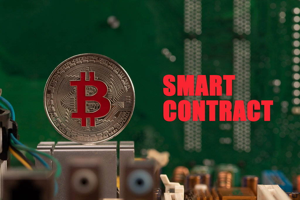 Silver Bitcoin on computer parts with Smart Contract text