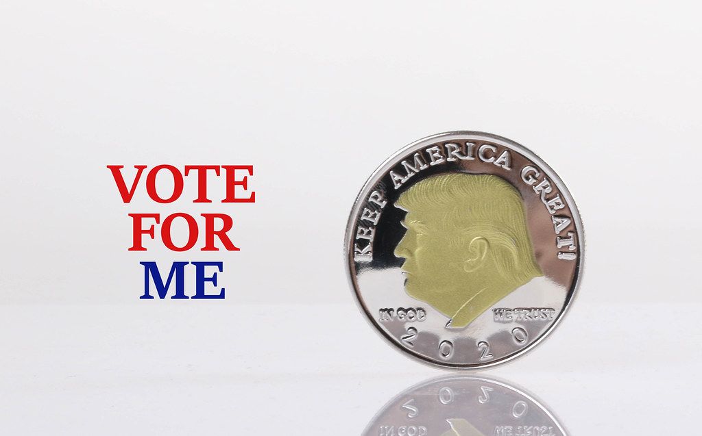 Silver coin with Donald Trump on it and Vote for me text
