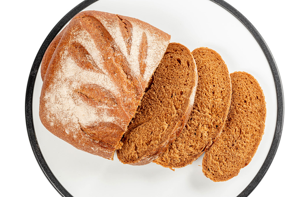 Slices of fresh rye bread on white background, top view