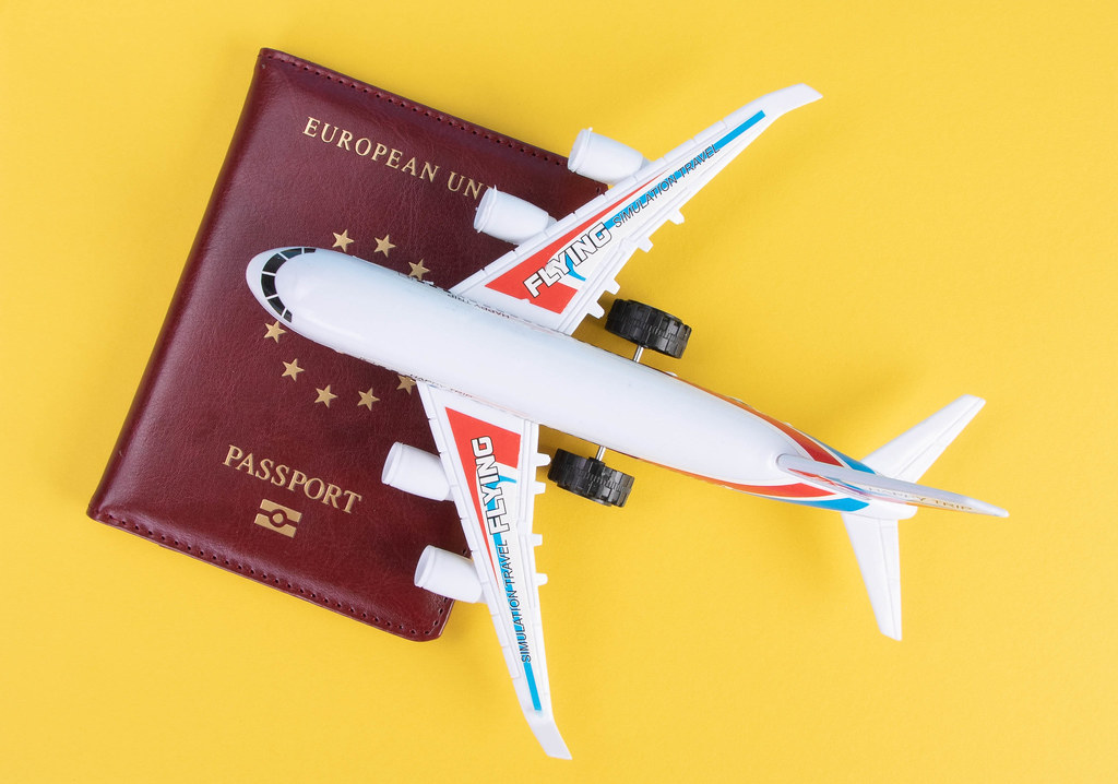 Small airplane on top of the passport with yellow background