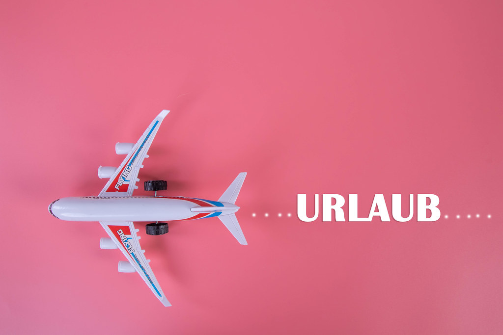 Small airplane with Urlaub text on pink background