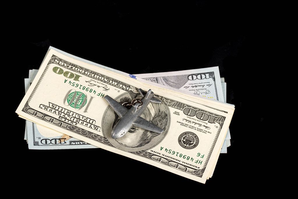 Small iron plane with dollars on a black background