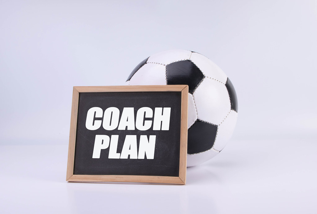Soccer ball and chalkboard with Coach Plan text
