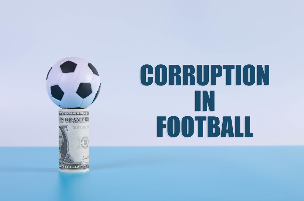 Soccer ball on a money roll with Corruption in Football text