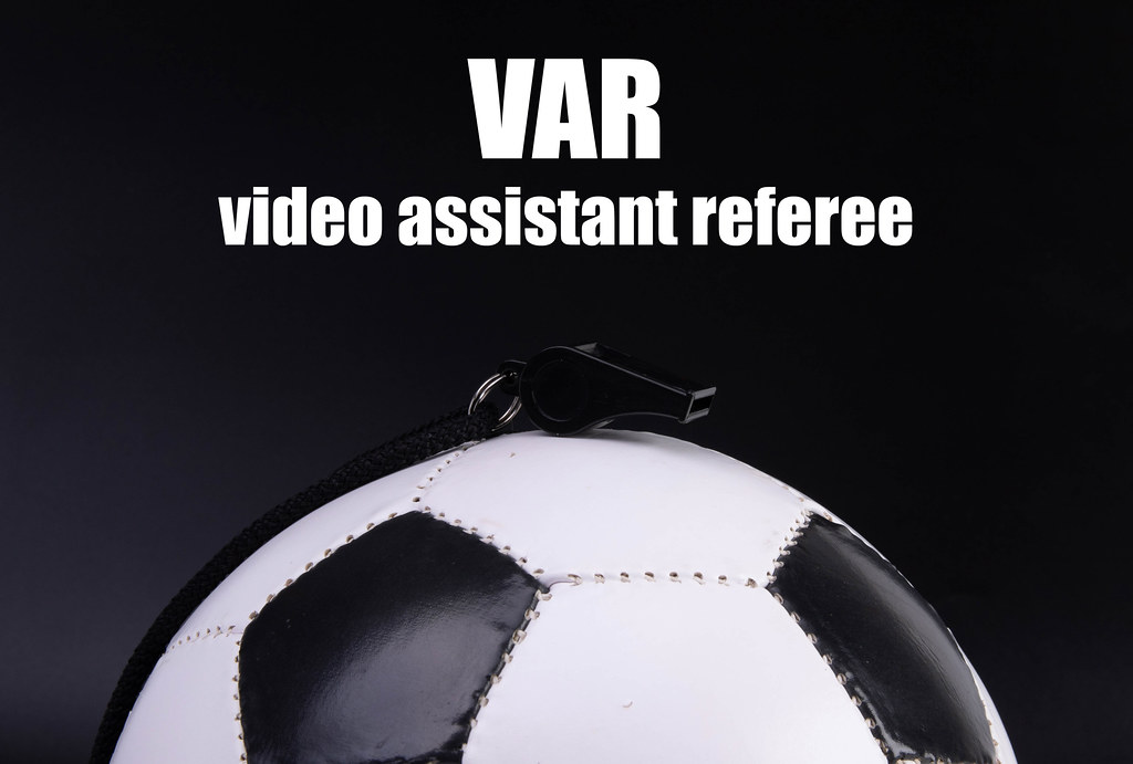 Soccer ball on black background with VAR video assistant referee text