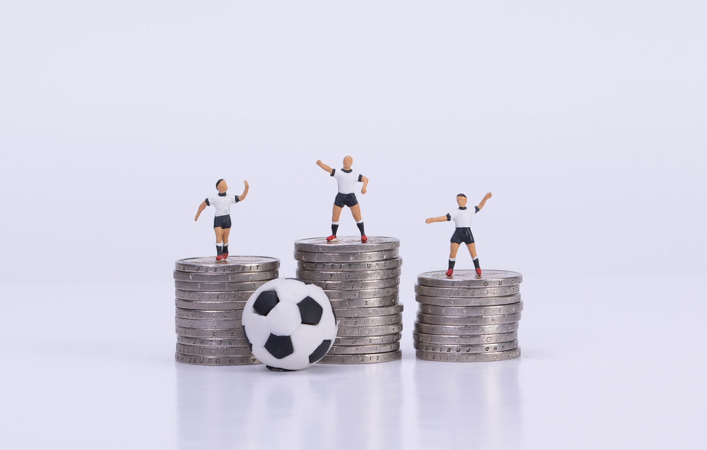 Soccer players standing on coinstacks