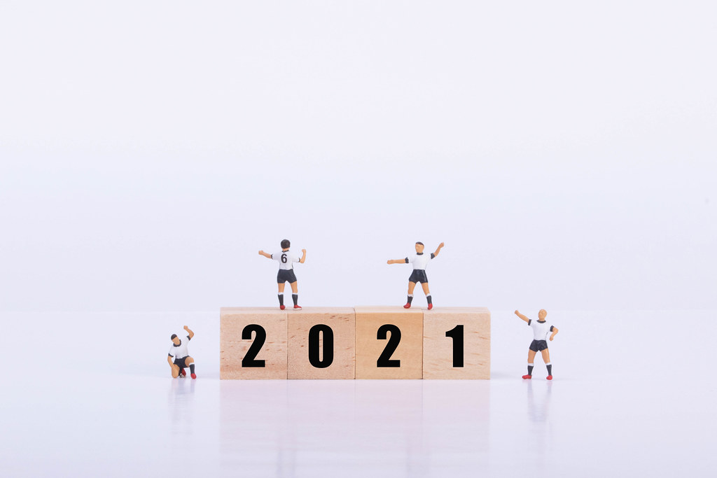 Soccer players standing on wooden cubes with 2021 text