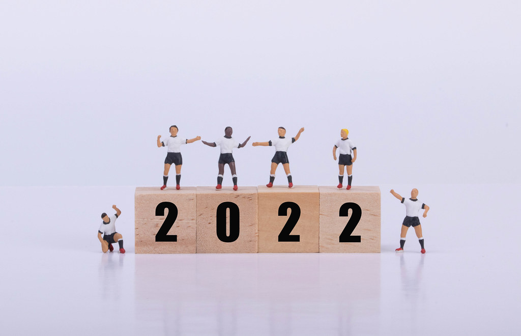 Soccer players standing on wooden cubes with 2022 text