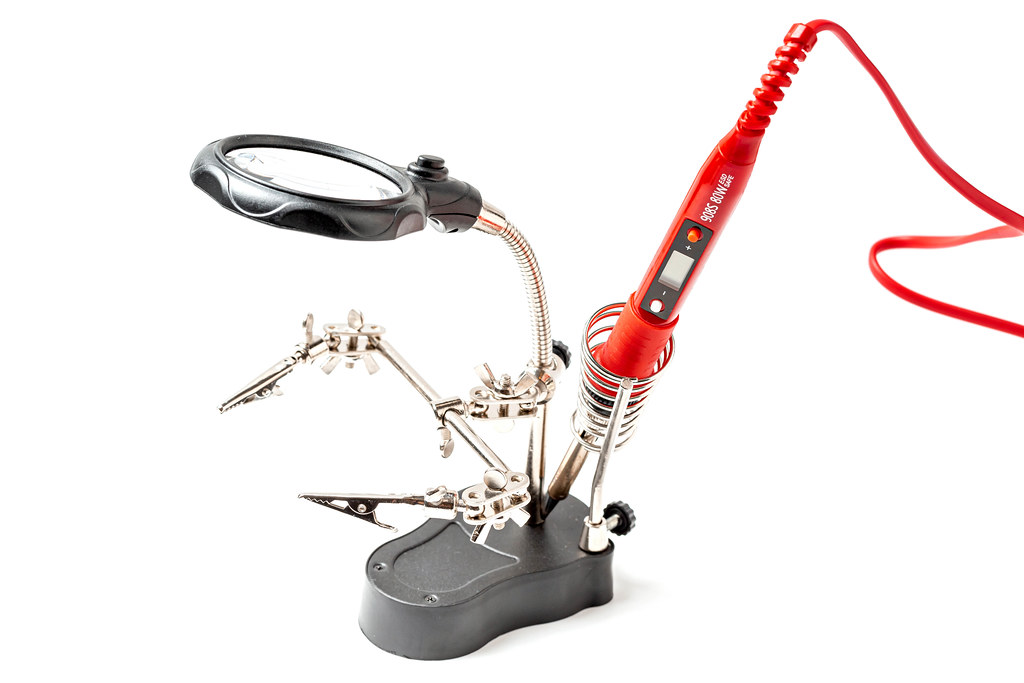 Soldering iron on stand with magnifying glass and clips