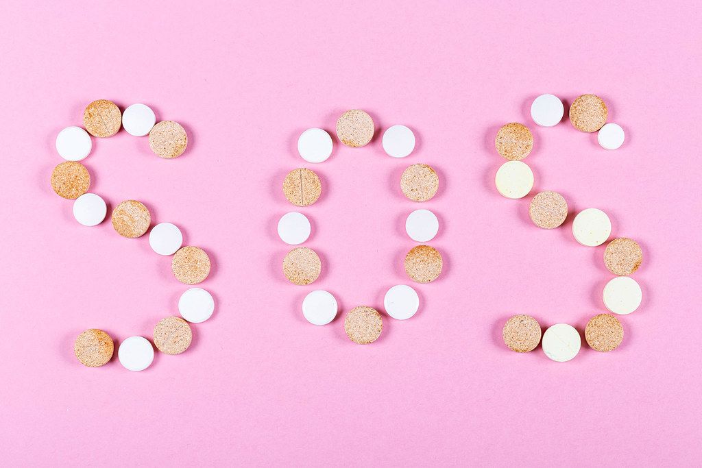 SOS from pills on a pink background