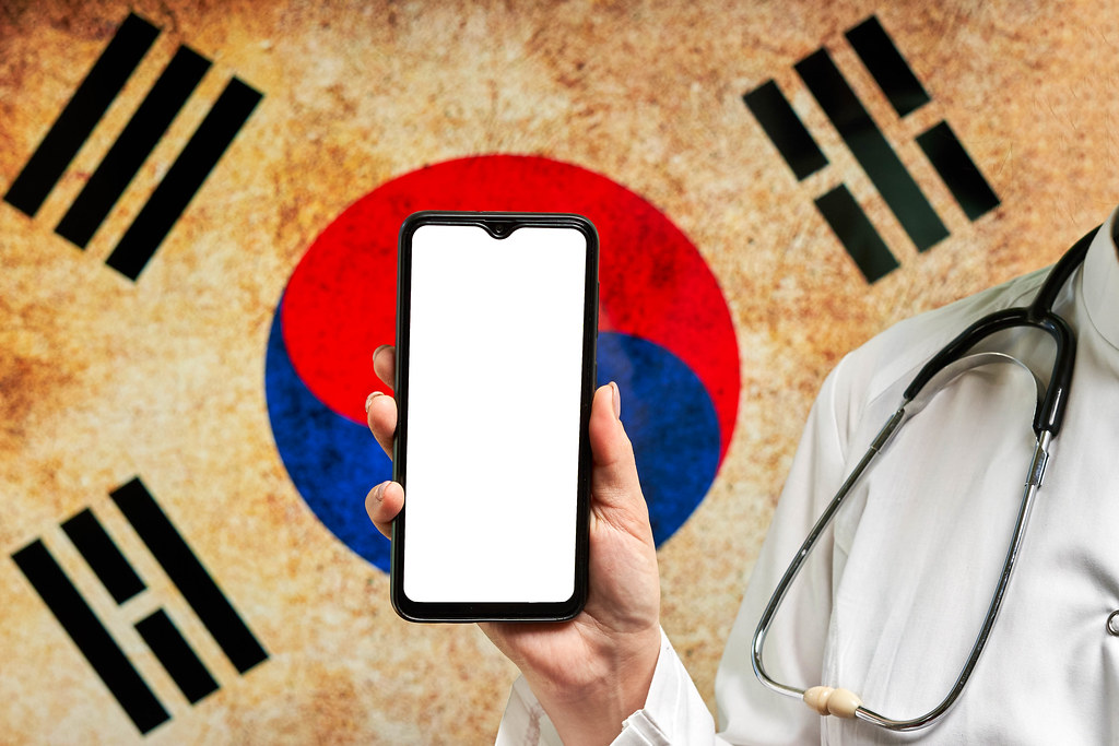 South Korean doctor holds a cell phone with a blank display