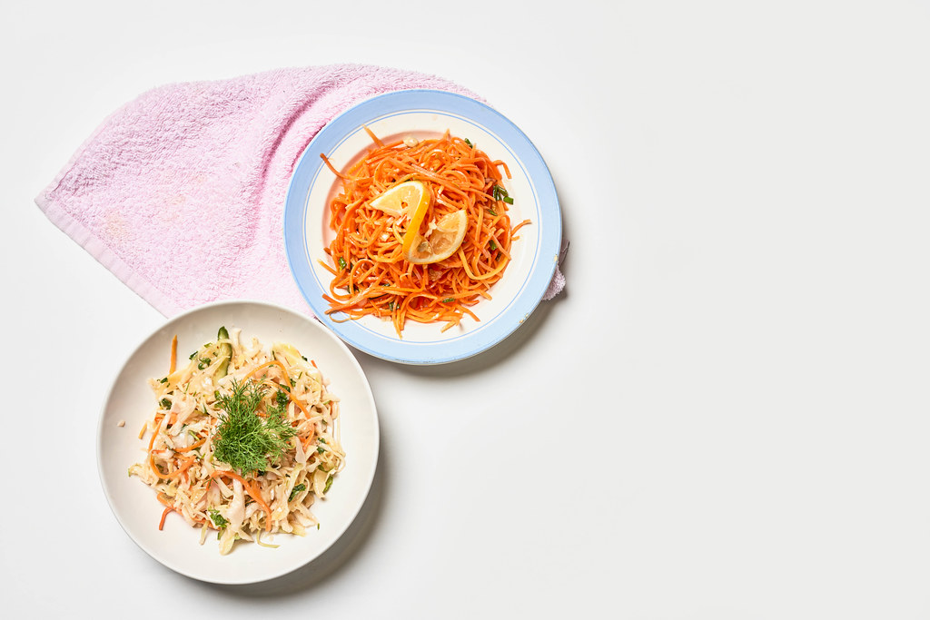 Spicy korean salads with carrot and cabbage on white background