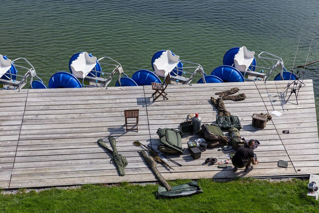 Sport fishing at Reintalersee in Kramsach: an angler prepares his fishing equipment on the pier
