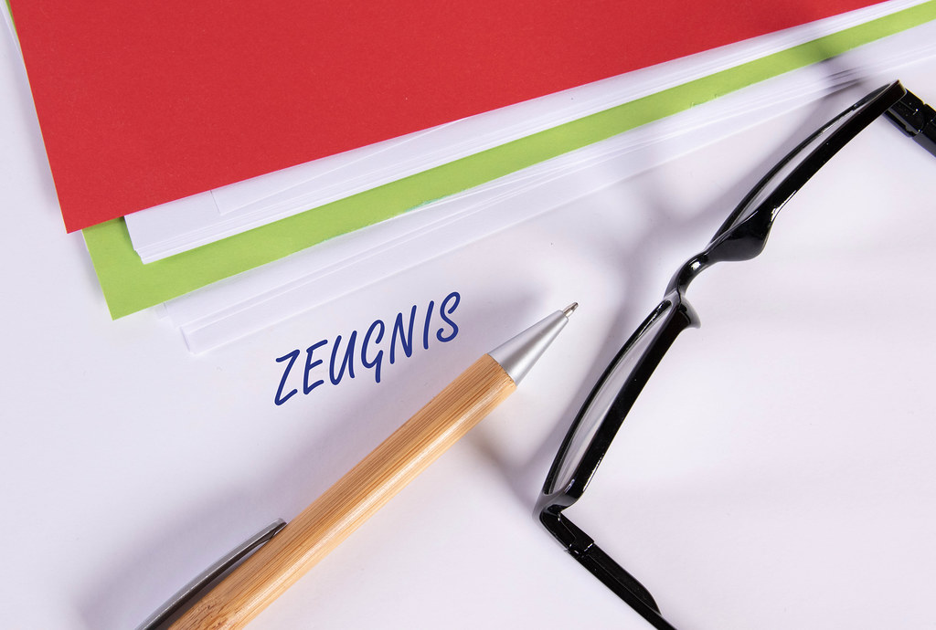 Stack of papers with pen, glasses and Zeugnis text