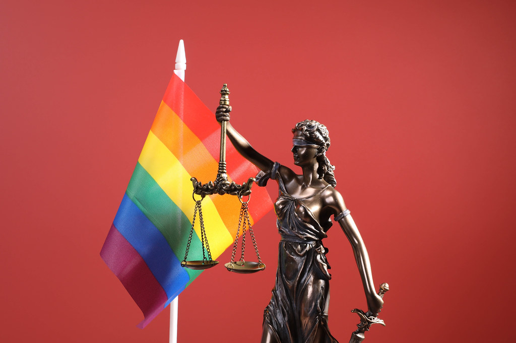 Statue of Lady Justice and rainbow flag