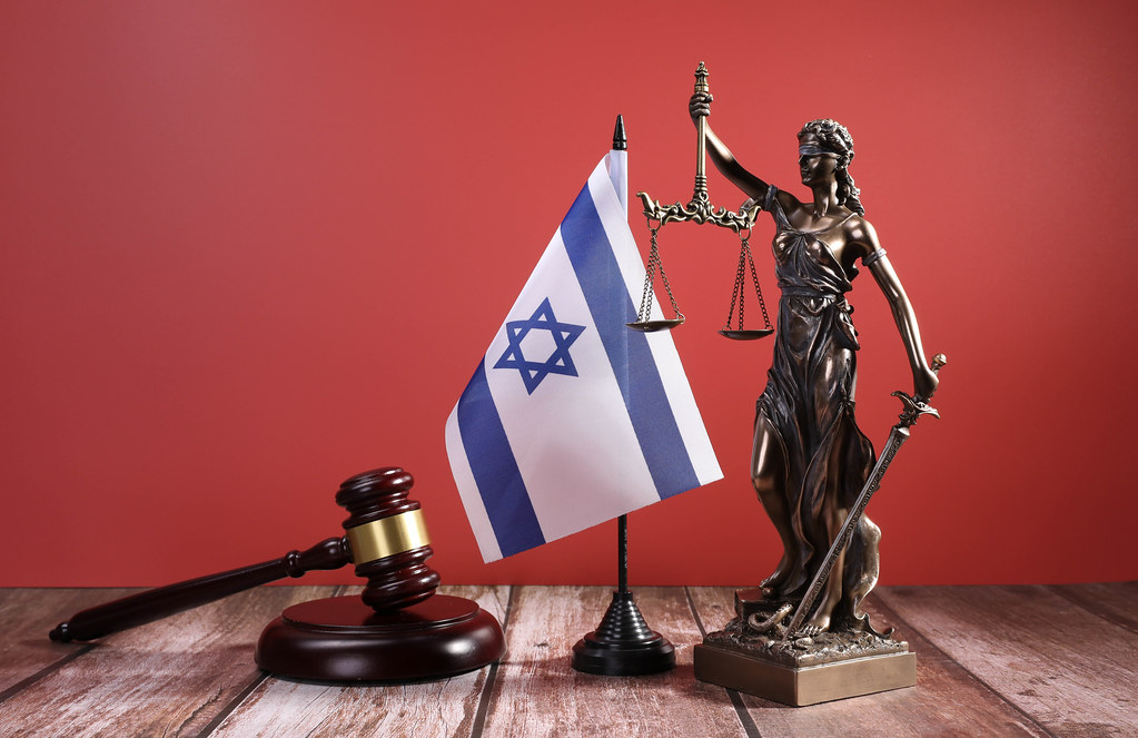 Statue of Lady Justice with Judge gavel and flag of Israel