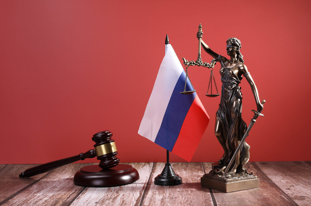 Statue of Lady Justice with Judge gavel and flag of Russia