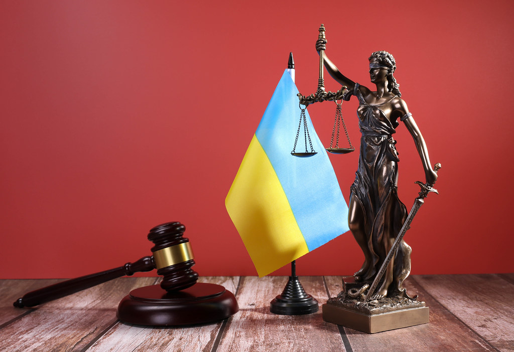Statue of Lady Justice with Judge gavel and flag of Ukraine