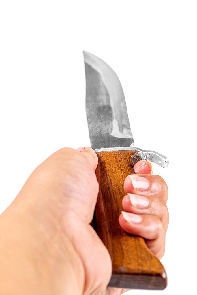 Steel knife with a wooden handle in a female hand