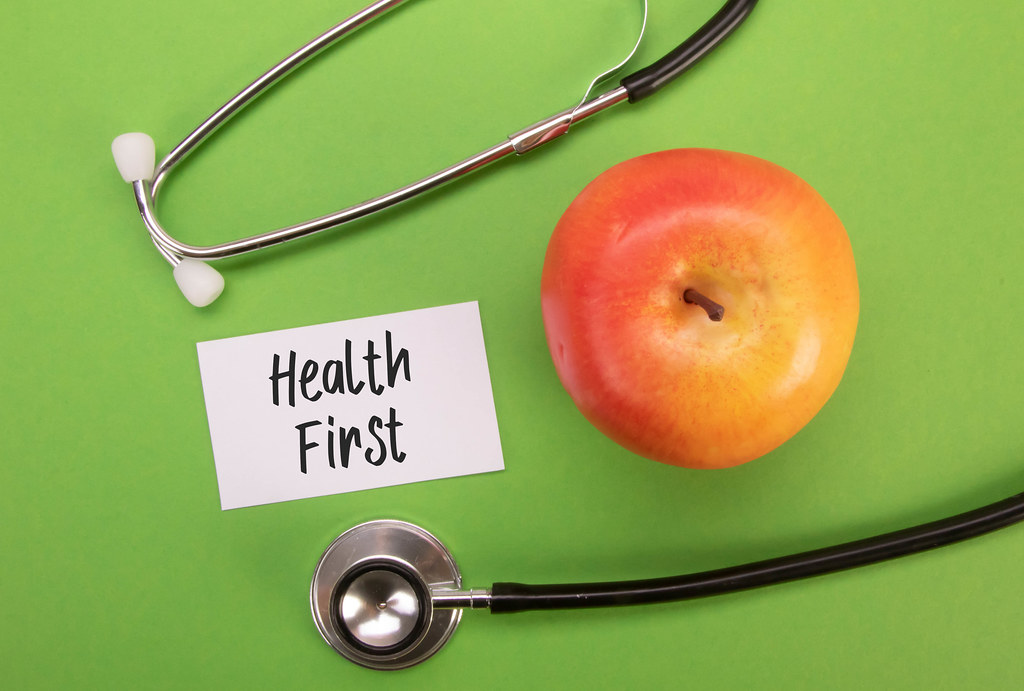 Stethoscope and red apple with Health First text