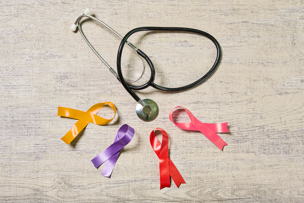 Stethoscope colorful awareness ribbons on wood background