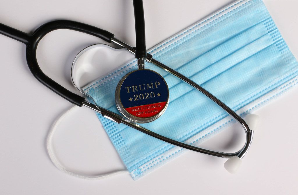 Stethoscope, face mask and coin with Trump 2020 text