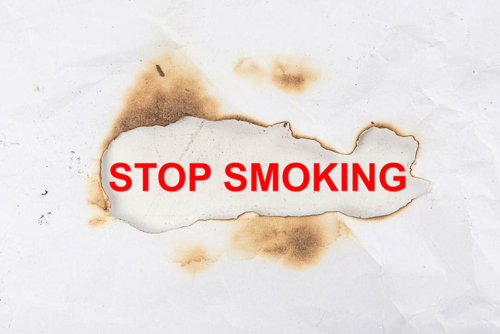 Stop smoking - red lettering in a burnt paper frame