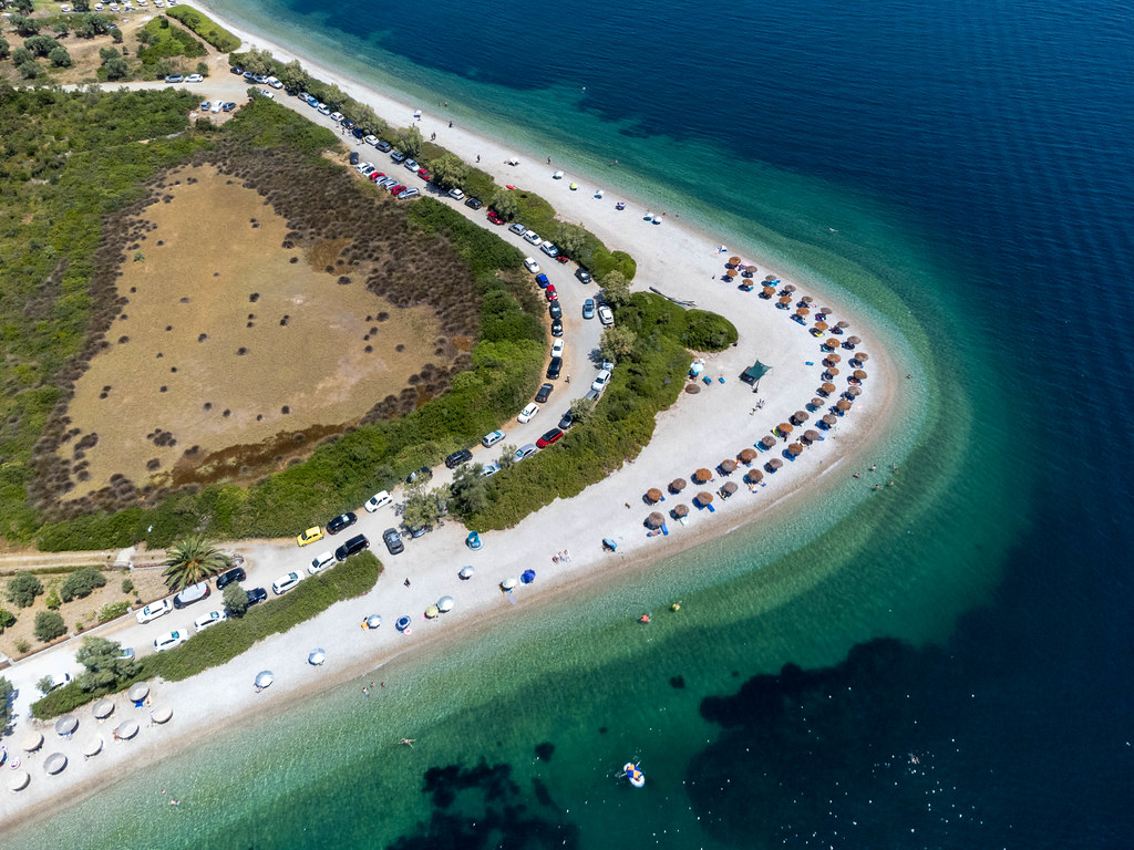 Strand in Hufeisenform in Griechenland: Draufsicht auf Agios Dimitrios (Alonissos) mit Strohsonnenschirmen