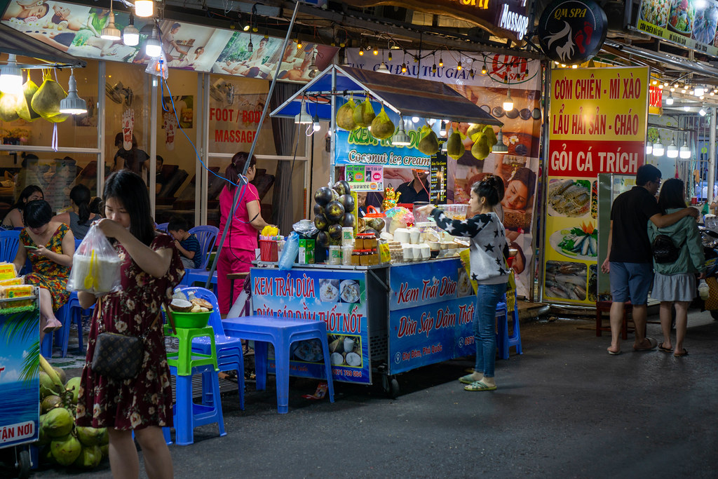 Street Food Vendor selling Coconut Ice Cream, Restaurants and Massage Parlors at the Phu Quoc Night Market in Vietnam