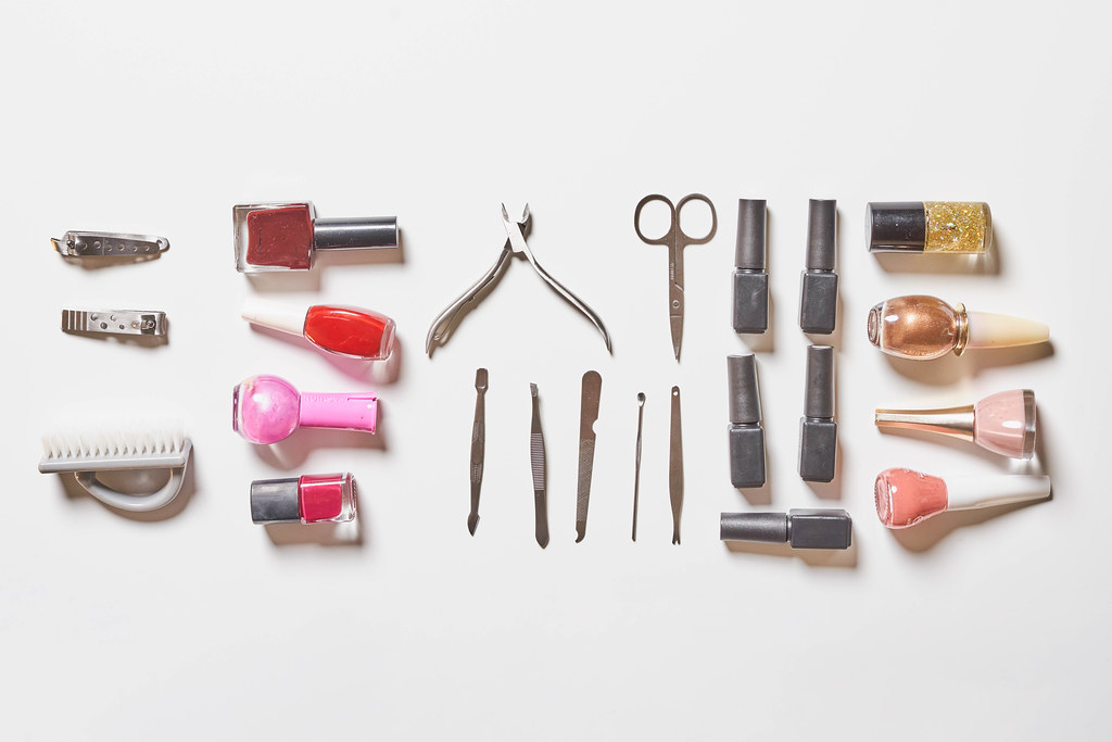 Stylish trendy manicure accessories with gel nail polishes, scissors, cuticle pusher and other tools