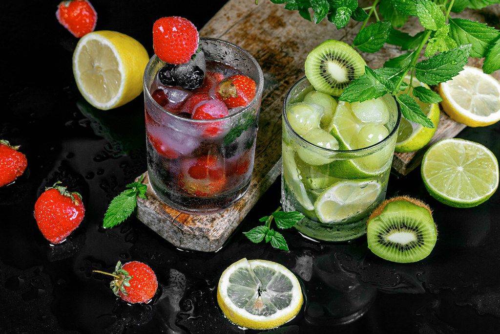 Summer fruit cocktails with ice, berries and mint