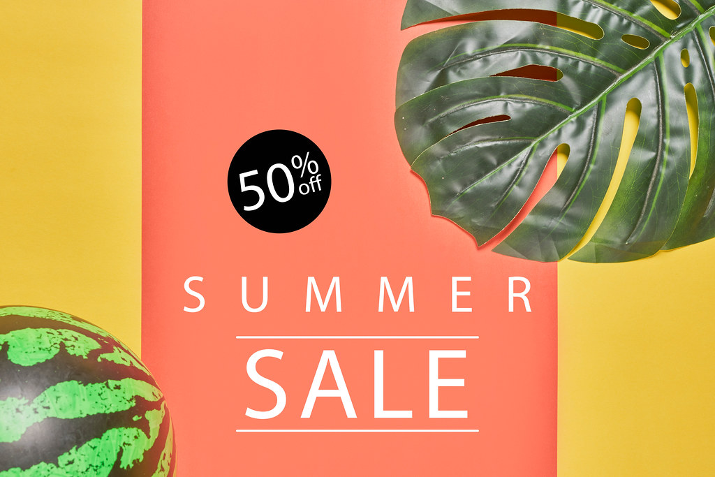 Summer sale with palm leaves and ball on a bright color background