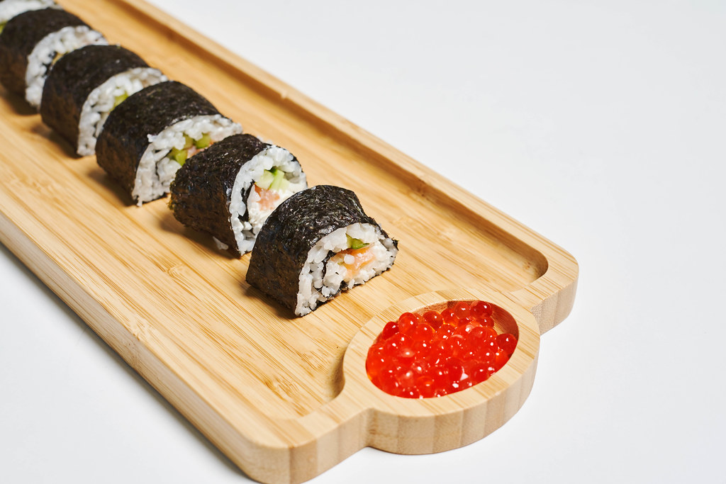 Sushi rolls served on a wooden plate in a restaurant