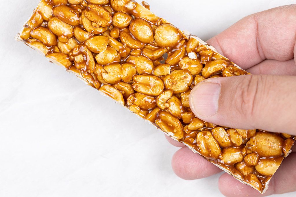 Sweet Peanuts Bar in the hand with copy space