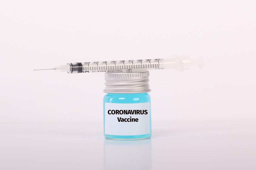 Syringe and bottle with blue fluid and Coronavirus Vaccine text