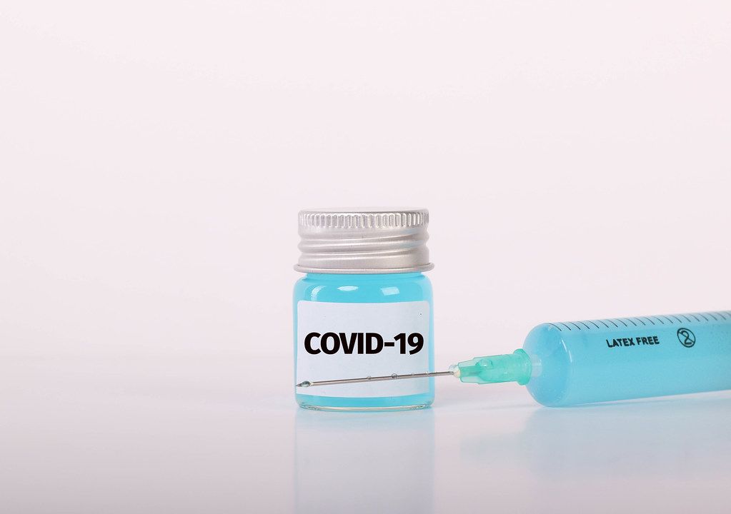 Syringe and bottle with blue fluid and Covid-19 text