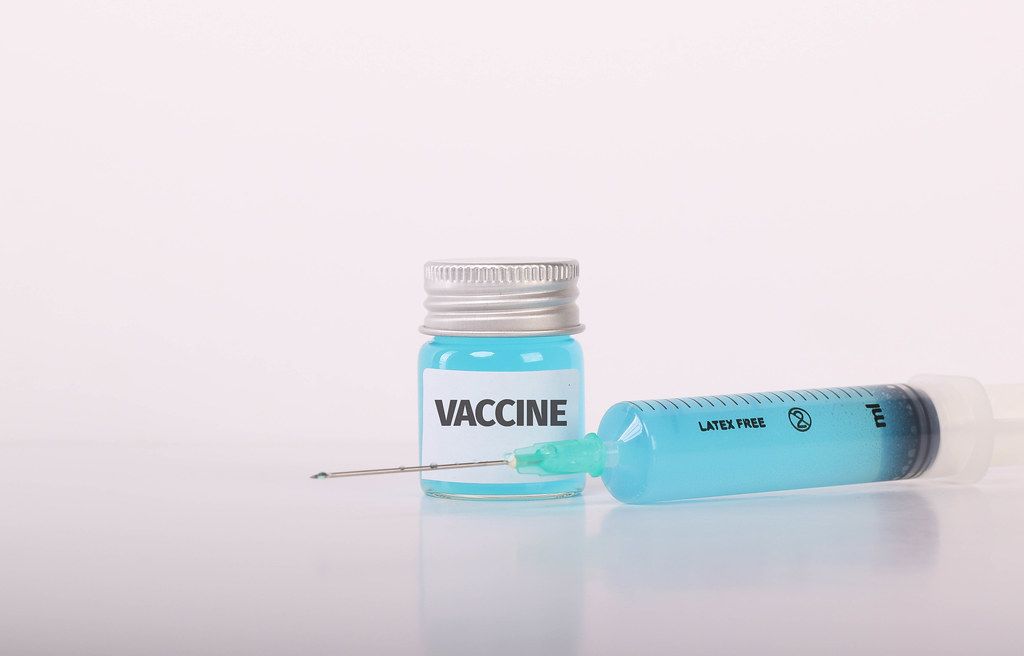 Syringe and bottle with blue fluid and Vaccine text