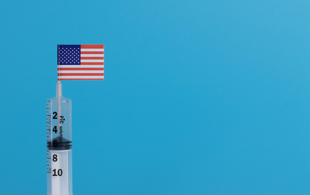 Syringe with flag of USA on blue background