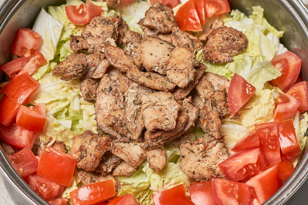 Tasty salad with chicken meat, tomato and cabbage leaves