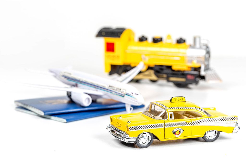 Taxi car, airplane, train and passports on a white background. The concept of choosing a vehicle for travel
