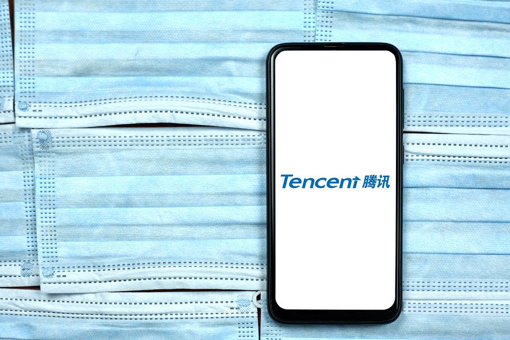 Tencent logo seen displayed on smart phone over the face masks