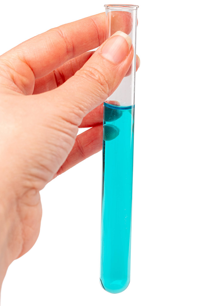 Test tube with blue liquid in hand, concept of evaluation of experience results