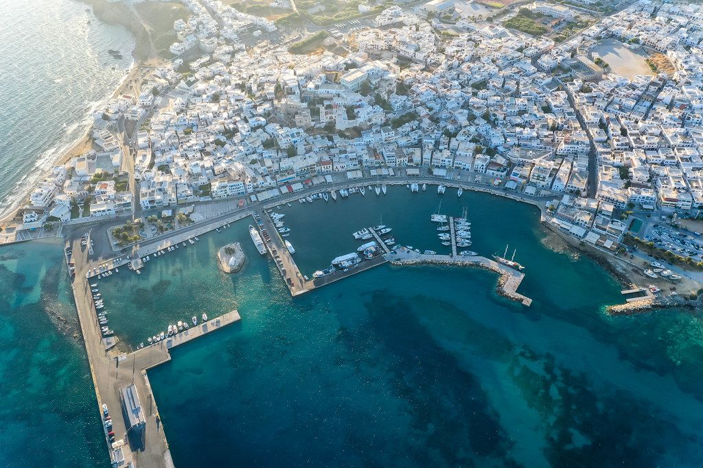 The capital and port town of Naxos, Chora. Aerial shot of the harbour with piers, boats and blue waters