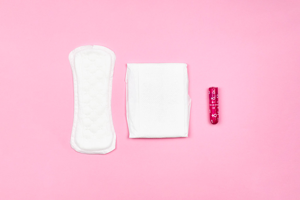 Three different types of feminine hygiene products on pink background
