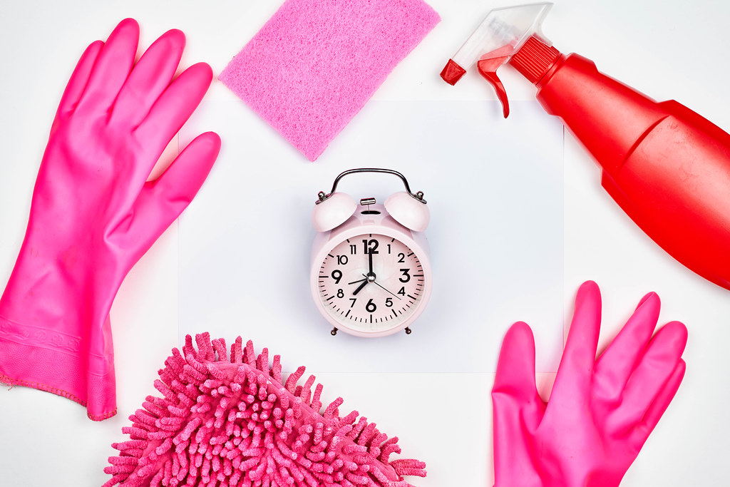 Time for spring cleaning: white background with cleaning products: gloves, spray bottle, sponge