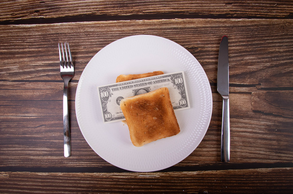 Toasted bread on a plate with dollar banknote
